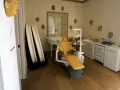 Una sala con una silla de dentista con máscaras colgadas en la pared