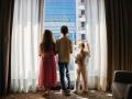 Tres niños miran a través de la ventana de un hotel