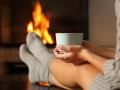 Woman with socks holding coffee in a fireplace