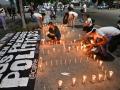Familiares de presos políticos encienden velas en una vigilia para exigir la liberación de sus seres queridos, cerca de El Helicoide