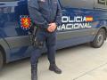 Agente de la Policía Nacional junto a su vehículo