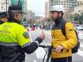 Imagen de archivo de un policía local hablando con un usuario de patinete eléctrico en el centro de Valencia