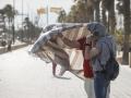 Imagen de dos personas protegiéndose del viento en Valencia