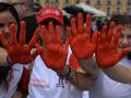 Personas participan en una manifestación para conmemorar el Día Internacional contra el Uso de Niños Soldados, también conocido como el Día de la Mano Roja, en la Plaza Bolívar de Bogotá