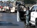 Un miembro de la Guardia Nacional se encuentra cerca de un autobús incendiado por grupos del crimen organizado