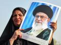 An Iranian woman holds a portrait of supreme leader Ayatollah Ali Khamenei as people celebrate a ceasefire between Iran and Israel at Enghlab Square in the capital Tehran on June 24, 2025. A fragile ceasefire in the Iran-Israel war appeared to be holding on June 24, after 12 days of strikes that saw Israel and the United States pummel the Islamic republic's nuclear facilities. (Photo by ATTA KENARE / AFP)