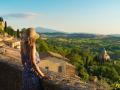 Mujer asomada a un balcón de Montepulciano con vistas a la Toscana