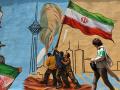 Una mujer iraní pasa junto a un mural antiestadounidense y antiisraelí en Teherán