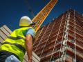 Un obrero observa la construcción de un edificio