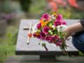 Una persona poniendo flores en un cementerio
