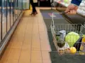 Gente comprando en un supermercado con la cesta de la compra