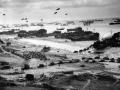 Buques de desembarco de tanques (LST) con globos de barrera desplegados, descargando suministros en la playa de Omaha para la retirada de Normandía