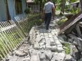 Personas observan los daños causados ​​por un terremoto de magnitud 7,8 en una zona residencial frente a las costas del sur de Filipinas