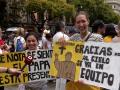 Dos jóvenes sostienen carteles con mensajes para el Santo Padre León XIV frente a la catedral de Barcelona