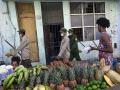 Soldados cubanos pasan junto a un puesto de frutas callejero mientras se dirigen a limpiar la basura acumulada en las esquinas de las calles debido al colapso del sistema de recolección de residuos en medio de la crisis que atraviesa el país, en La Habana Vieja, Cuba
