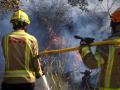 Bomberos trabajan en uno de los focos del incendio en la localidad de Calonge este sábado tras el incendio forestal que comenzó ayer en La Bisbal de l'Empordà (Gerona)