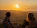 Dos personas mirando un espectacular eclipse solar parcial