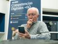 Un señor practica con el móvil durante los talleres Competencias Digitales +60