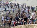 Entre los concentrados había familias enteras, mujeres, niños, jóvenes y personas de diferentes edades que avanzaron conjuntamente hacia la frontera. La Policía marroquí estableció un cordón en algunos puntos de acceso, aunque numerosos grupos lograron continuar su marcha por las colinas que rodean el perímetro fronterizo.