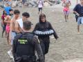 Un grupo de inmigrantes en la playa junto al paso fronterizo del Tarajal en Ceuta este viernes