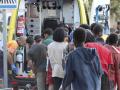 Inmigrantes hacen fila para ser atendidas por los servicios médicos este martes, en la playa El Trampolín de Ceuta