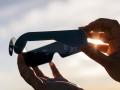 Person holding paper solar eclipse glasses, blocking the sun's direct rays for safe viewing during an astronomical event