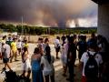 Vecinos de El Madroño, en Sevilla, observan este domingoo el fuego del incendio de Niebla (Huelva)
