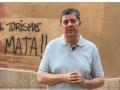 El conseller de Turismo, Jaume Bauzá, delante de la pintada turismofóbica en el edificio de la Conselleria