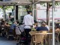 Clientes de un bar se refrescan en la terraza