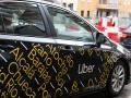 Coche Uber circula por una calle,