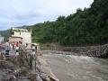 Unas personas permanecen cerca de un puente colapsado tras unas inundaciones repentinas en Devighat, en el distrito nepalí de Nuwakot