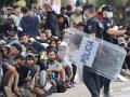 Inmigrantes frente a la explanada de embotellamiento de Loma Colmenar