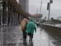 Vecinos de Barcelona pasean bajo la lluvia en la playa de la Barceloneta durante el temporal, a 19 de enero de 2026, en Barcelona, Cataluña