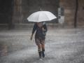 Imagen de una mujer protegiéndose de la lluvia en Valencia