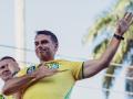 Brazilian right-wing presidential candidate Flavio Bolsonaro, of the Liberal Party (PL), gestures as he rides in a motorcade with supporters in the Jacarepagua neighborhood in Rio de Janeiro, Brazil, on September 26, 2026. Brazil will hold presidential election on October 4, 2026. (Photo by Douglas SHINEIDR / AFP)