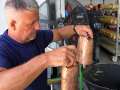Juan Chamizo sostiene dos cencerros fabricados artesanalmente en su taller familiar