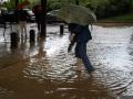 Una mujer cruza a través de la lluvia acumulada en la calle en el barrio de Canyelles-Nou Barris