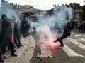 Una persona patea una bengala contra los agentes de policía que dispersan a los manifestantes al final de una protesta que forma parte de una jornada nacional de movilizaciones convocada por estudiantes de secundaria