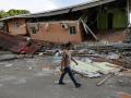 Un hombre camina cerca de una vivienda afectada el terremoto en Tonosí