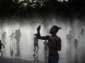 Varias personas se refrescan en las fuentes de Madrid Río