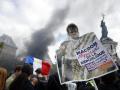 Un manifestante pide explicaciones al presidente de Francia, Emmanuel Macron