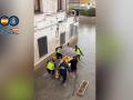 Imagen del rescate de la Policía a una anciana de 93 años en Gandía con una tabla de pádel surf
