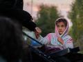 Una niña espera junto a su madre en las "colas del hambre" de la Fundación Madrina