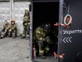 Rescatistas ucranianos descansan en el lugar donde se encontraba un centro comercial dañado tras un ataque con misiles en Kiev