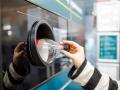 Una mujer devuelve una botella de refresco en una máquina habilitada para ello