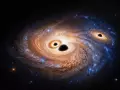 Ilustración de una galaxia distante que contiene, además de polvo, gas y estrellas jóvenes, tres agujeros negros masivos