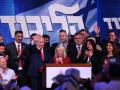 El primer ministro israelí, Benjamin Netanyahu (centro izquierda), saluda a sus seguidores junto a su esposa Sara en el mitin de la noche electoral tras el anuncio de los primeros sondeos a pie de urna, en Jerusalén