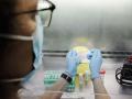 Una técnico de laboratorio sostiene pruebas de análisis