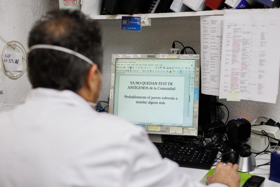 farmacéutico se dispone a imprimir un cartel para anunciar que los test de antígenos de la Comunidad de Madrid están agotados ayer, miércoles