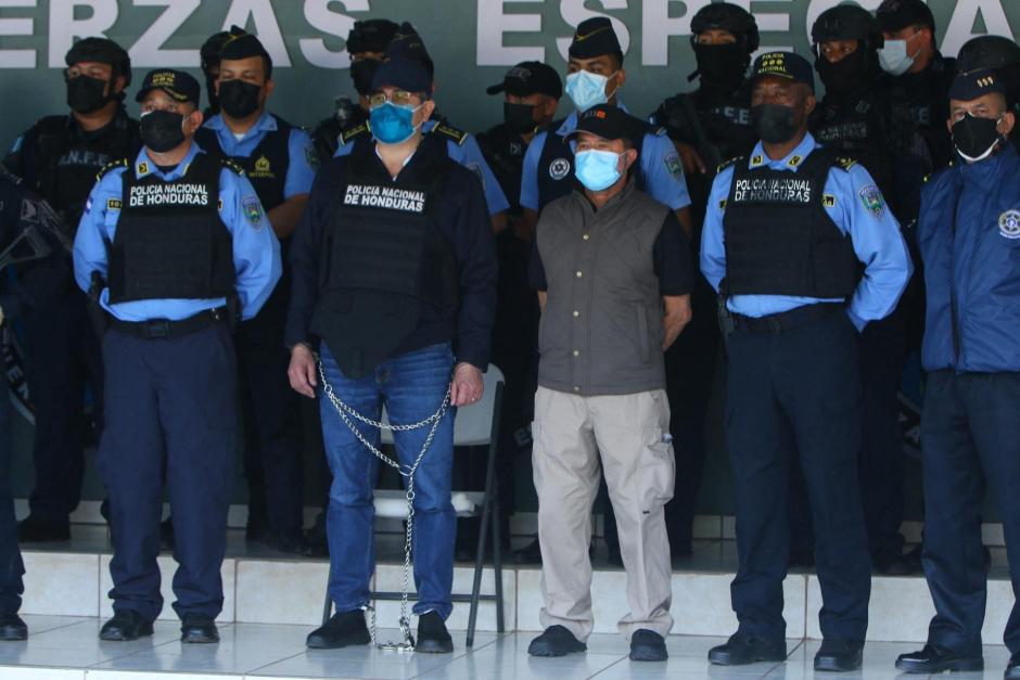This handout picture released by the Honduran Police shows Honduran former President Juan Orlando Hernandez (L) being handcuffed as members of the police take him out of his house after receiving an extradition order from the United States, in Tegucigalpa, on February 15, 2022. - The United States has asked Honduras to extradite its former president Juan Orlando Hernandez, who left office last month and is suspected of drug trafficking, a source close to the matter told AFP Monday. The Honduran Foreign Ministry had said earlier on Twitter that an "official communication from the US Embassy" had been sent to the Supreme Court formally asking for the provisional arrest of an unnamed "Honduran politician" for the purpose of extradition. (Photo by HONDURAN POLICE / AFP) / RESTRICTED TO EDITORIAL USE-MANDATORY CREDIT - AFP PHOTO / HONDURAN POLICE - NO MAFRKETING - NO ADVERTISING CAMPAIGNS - DISTRIBUTED AS A SERVICE TO CLIENTS